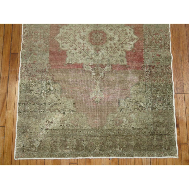 A vintage Turkish rug with a central medallion on a pink field. accents in white and brown Measures: 3'10'' x 5'6''.
