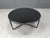 Hand made brutalist steel frame coffee table with a round black inserted glass. Gorgeous and suclptural tripod coffee...