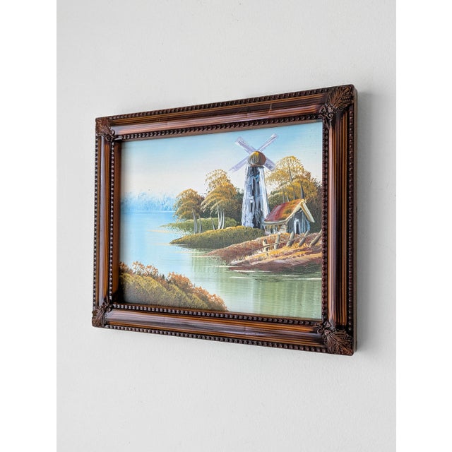 A framed Mid Century oil painting depicting a charming windmill in a countryside landscape, unsigned. Dimensions: canvas...