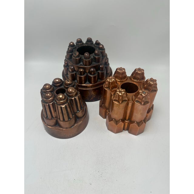 This is a highly distinctive group of antique copper culinary molds, unified by architectural form, repetition, and...