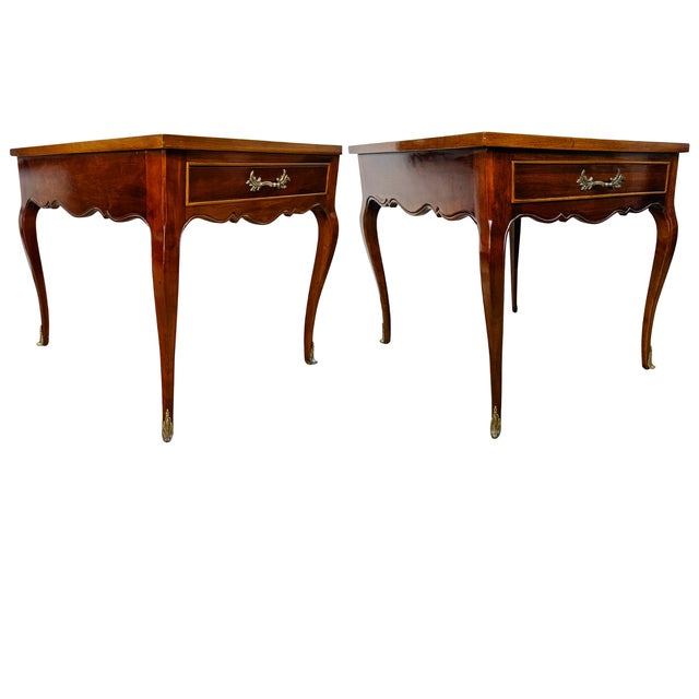 A pair of sophisticated 1970s French Provincial style side tables by Sherrill Furniture featuring a high-gloss, reflective...