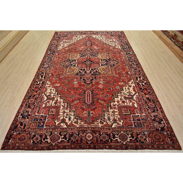 An authentic vintage tribal Heriz rug hand-knotted with fine wool and natural dyes. This nomadic rug features a central...