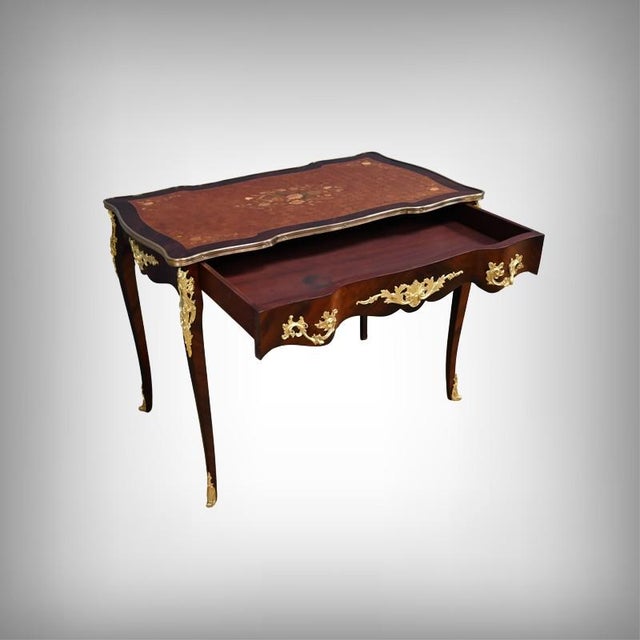 Elegant and refined, this early 20th-century writing desk perfectly illustrates the revival of curved forms and precious...