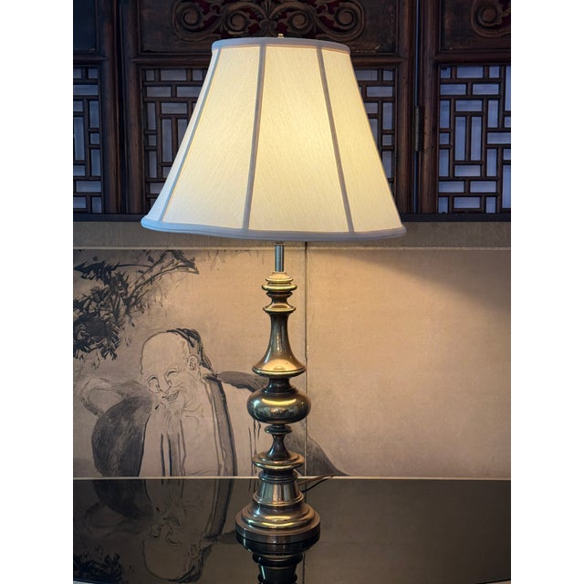 Design Plus Gallery presents a Vintage Brass Table Lamp. This traditional lamp has a tall urn-form profile with stacked...