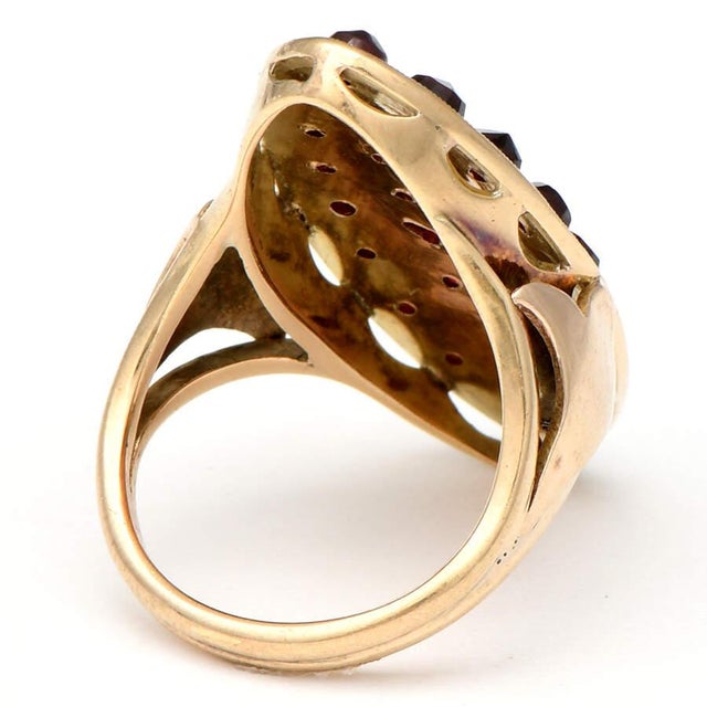 With an oval shape and a multi-stone display forming a clustered aesthetic, this 14KY garnet cluster ring's rose-cut bead...