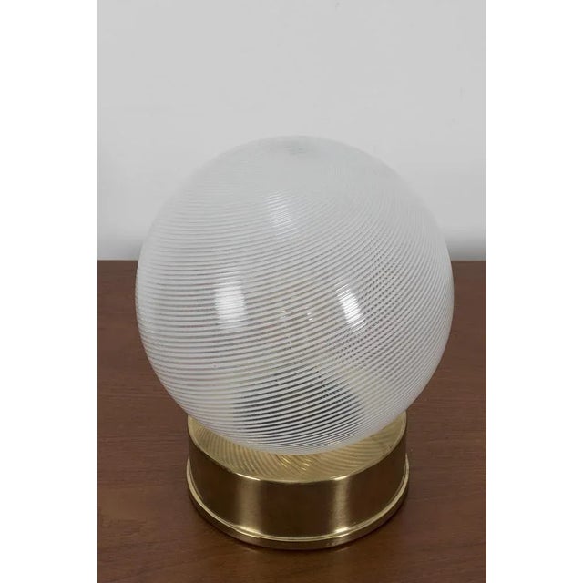 Italian table lamp, style Venini, with playful swirl design on the glass. The base is made from brass. In good vintage...