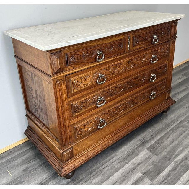 This elegant Antique French chest of drawers is a beautifully crafted piece, combining rich carved detailing with a...