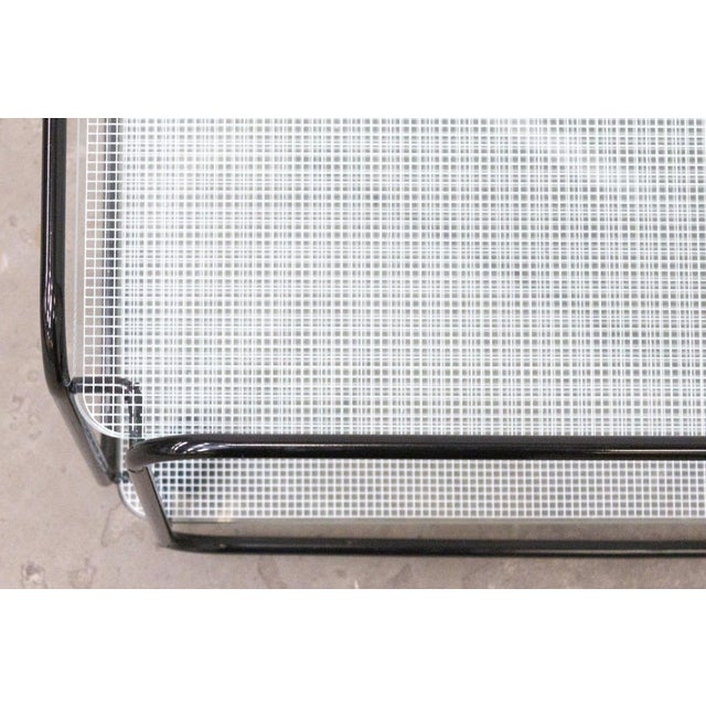 Italian-made coffee table. The tubular metal frame supports two glass shelves, creating a light and well-proportioned...