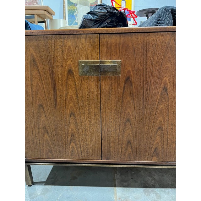 Mid Century Modern walnut sideboard with bronze base and hardware, attributed to Founders Furniture. This cabinet has...