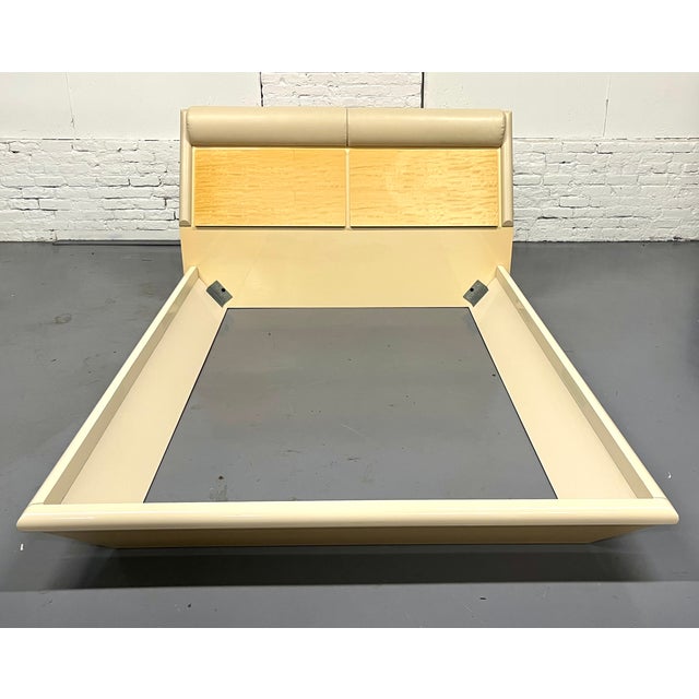 Long discontinued lacquered queen bed trimmed in leather with a satinwood headboard. with two generous drop down storage...