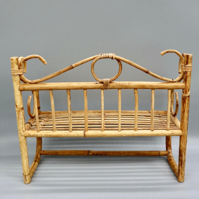 A charming vintage bamboo and rattan wall shelf with a built-in towel bar along the front, scrolled arm details, and a...