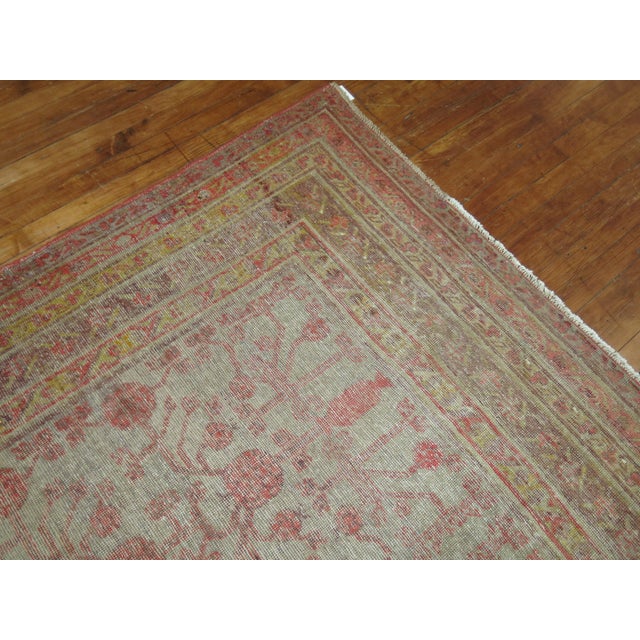 A worn early 20th century Khotan gallery rug. Gray ground, soft red accent pomegranates throughout. accents in yellow and...