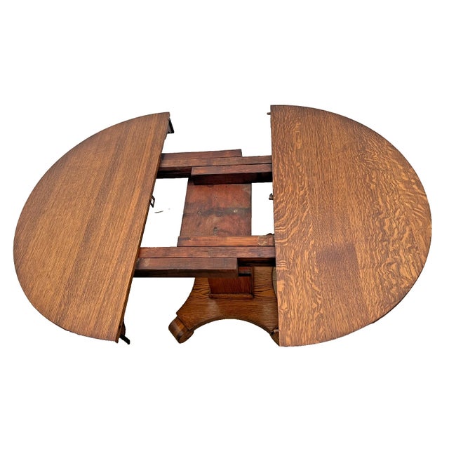 Beautiful antique solid quarter-sawn oak dining table featuring a round top with one Leaf. The table showcases striking...