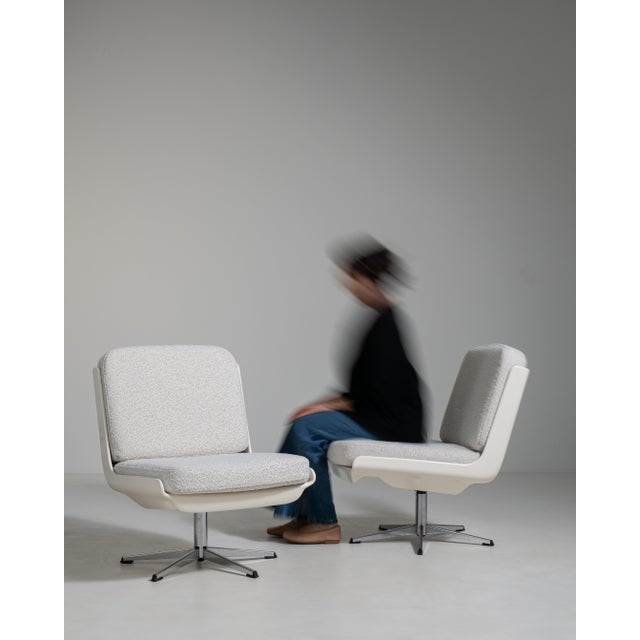 A collection of mid-century Space Age swivel chairs characterized by rounded forms and functional bases. These chairs...