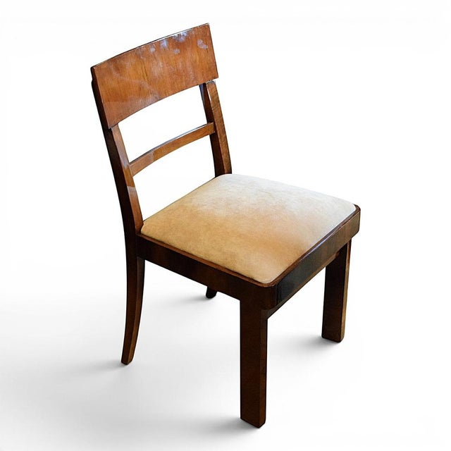 A set of four elegant Art Deco-style chairs, crafted from veneered wood with a warm, walnut-coloured finish. The simple,...