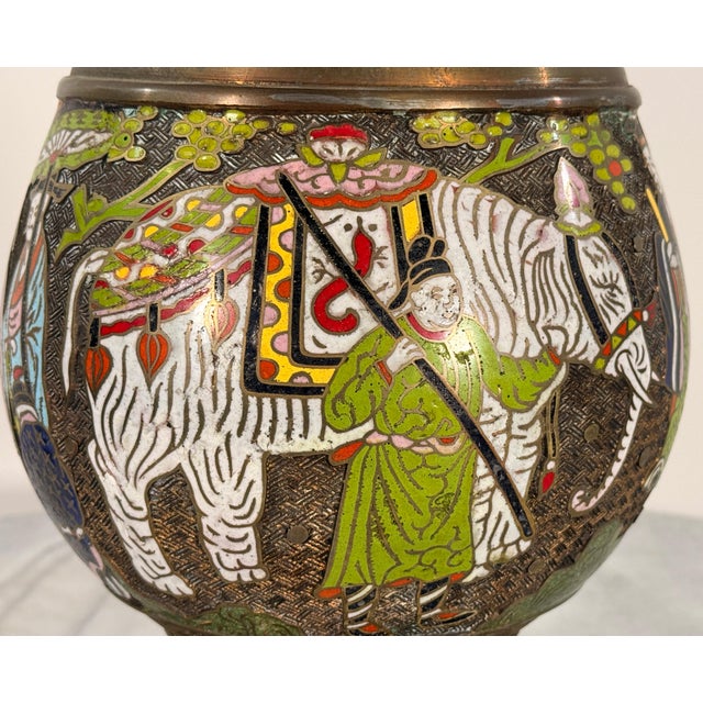 This substantial cloisonné lamp is built around a brass vase with an exceptionally detailed figural program: a continuous...