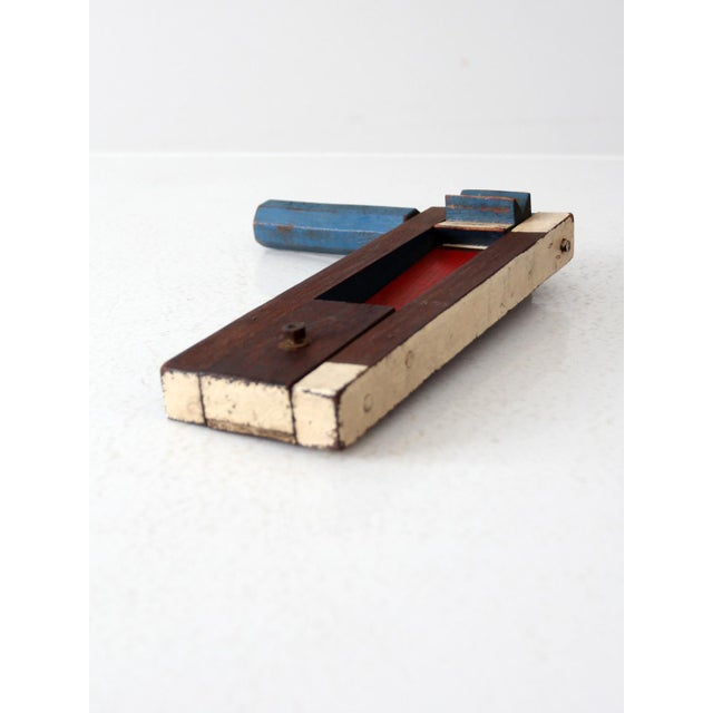 This early 20th-century wooden noisemaker alarm is painted in bold red, white, and blue. Built to create a loud, piercing...