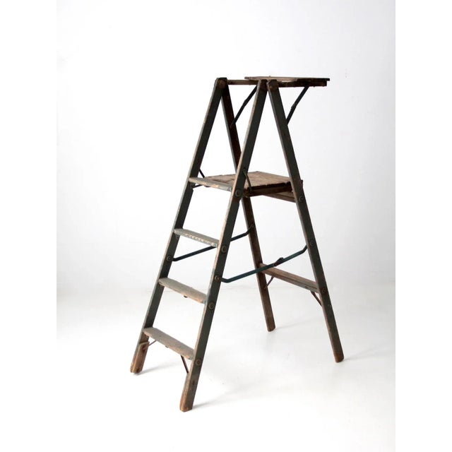A vintage wooden platform ladder in a distinctive teal blue finish, featuring four step rungs, a generous top platform,...