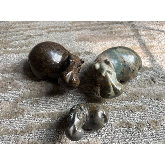 A beautiful set of three carved stone Hippos from Zimbabwe, each rendered in a different colorful variegated stone, the...