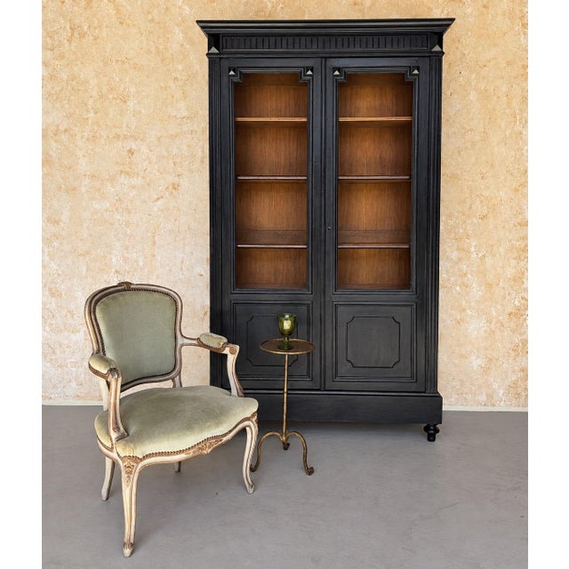 A handsome late 19th-century French Napoleon III style ebonized bookcase, distinguished by its elegant proportions and...