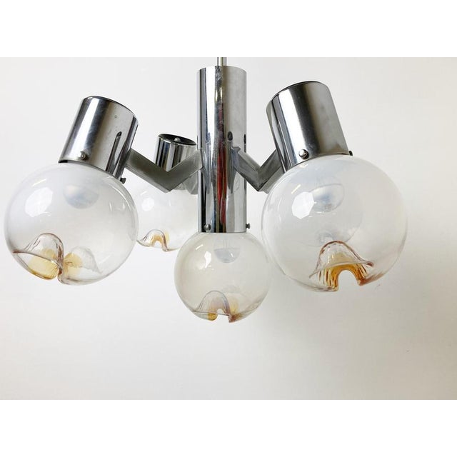 5 globe murano glass chandelier with a chromed metal frame by Mazzega AV - italy. The chandelier creates a beautiful...