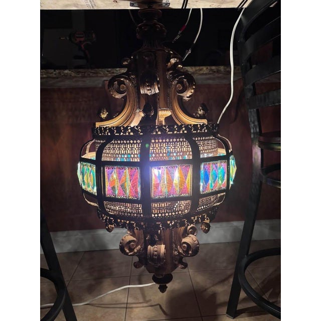 Striking Spanish Revival style hanging lantern chandelier featuring ornate sculptural detailing and vibrant faceted prism...