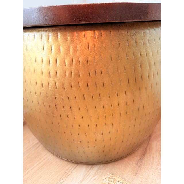 Striking vintage brass-clad drum table featuring a richly textured hammered finish and substantial solid wood removable...