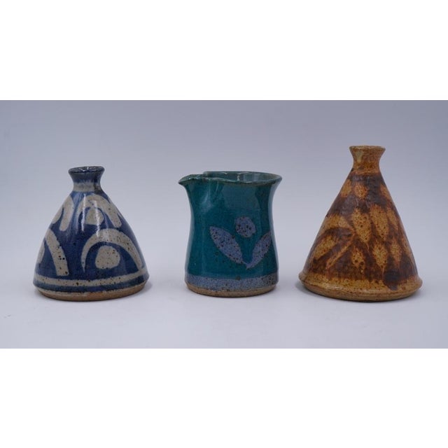 Collection of three small JT Abernathy (b. 1923) Ann Arbor, Michigan pottery vessels. Two are cone shape vases one in blue...