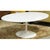 This piece features a smooth white oval top supported by a sculptural pedestal base that gives it a clean, uninterrupted...
