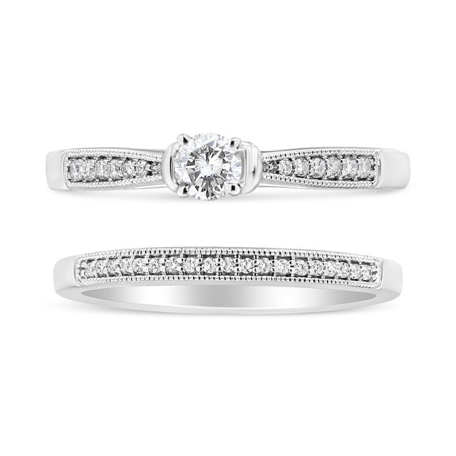 Draped in the luminous embrace of rhodium-plated .925 sterling silver, this bridal set merges tradition with the allure of...