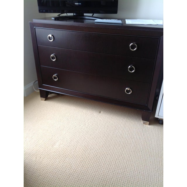 French Art Deco inspired (three) drawer chest in mahogany veneers with nickel ring pulls and sabot. Finish: Dark coffee...