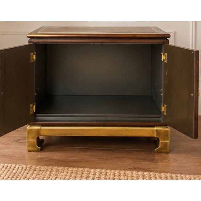 Striking 1970s Hollywood Regency cabinet by Baker Furniture, combining Asian Modern styling with the glamorous brass...