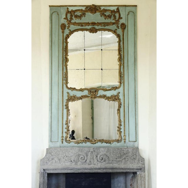 This large overmantel mirror in carved wood, from the Transition period (18th century), marks the evolution between the...