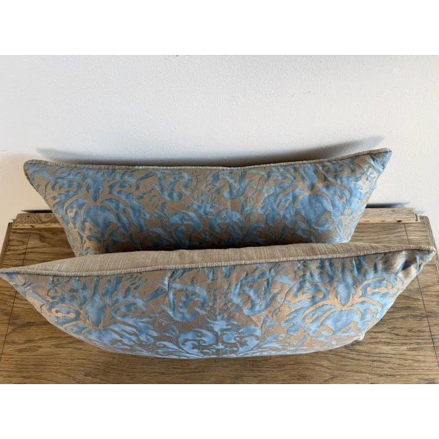 An elegant pair of decorative pillows crafted from luxurious Fortuny fabric, celebrated for its rich texture, historic...