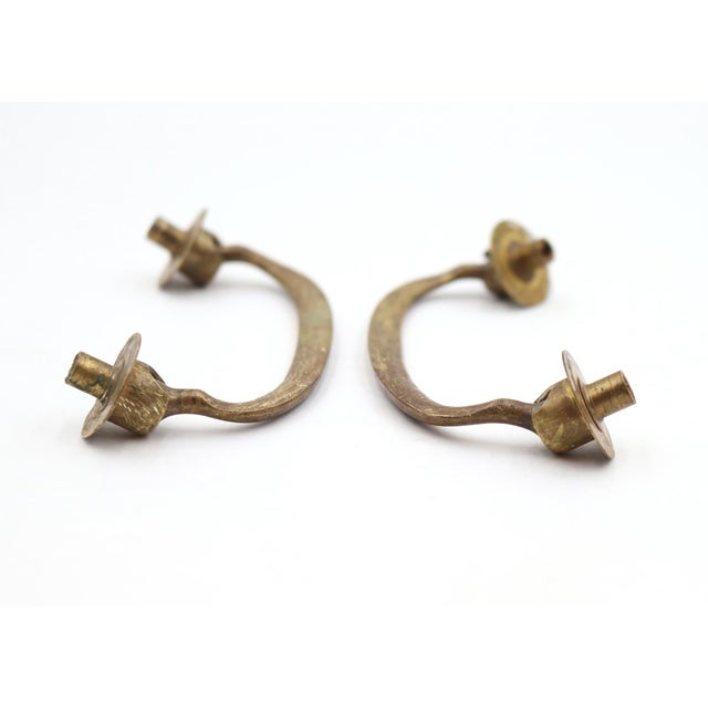 Vintage drawer pulls made of brass with a thin curved bridge design. The original mounting screws are included. Good...