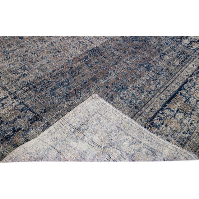 Beautiful antique Tabriz hand-knotted wool rug with the distressed brown field. This Persian piece has blue accents in a...