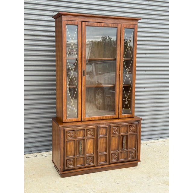 C. 1972 mid-century modern china hutch cabinet. The glass has an etched geometric design and the interior has two shelves...
