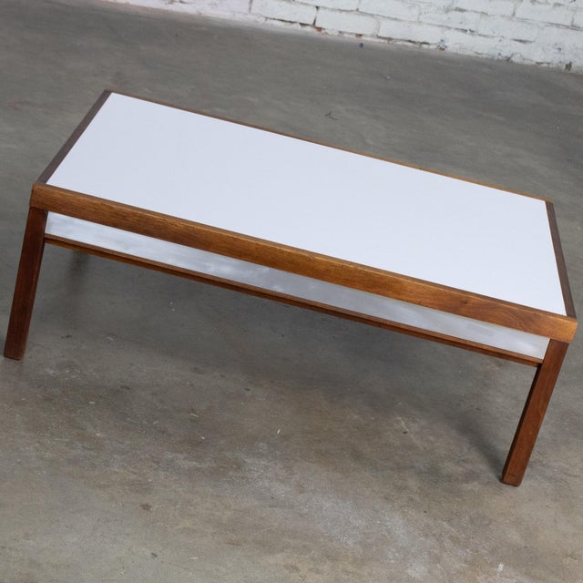 Marvelous vintage MCM (Mid-Century Modern) coffee or end table composed of a rectangular walnut frame with a white...