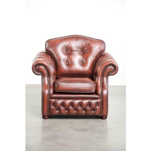 This unique cowhide Chesterfield armchair features a warm brown color scheme and is finished with decorative nails. It...