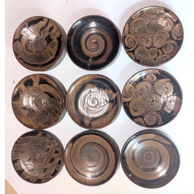 Offered is a set of 9 wheel-thrown glazed stoneware plates made in the late 1990s. They are each different on the surface...