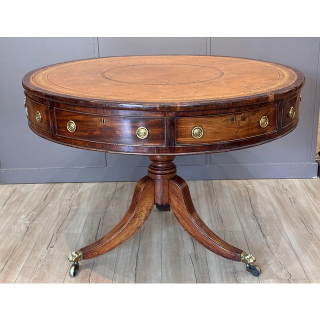 Early 19th C English mahogany drum table, the circular top inset with tan leather within a gilt-tooled border, the frieze...