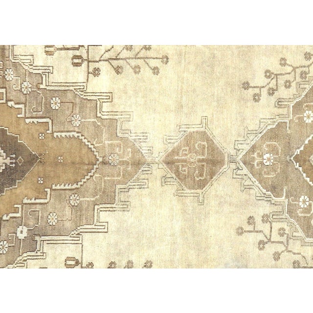 A vintage Turkish Oushak measuring 6'11" x 16'7", hand-woven with wool on wool foundation. This piece displays the...