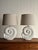 A pair of plaster table lamps formed in a spiral shell shape with a matte white finish and ribbed detailing. Light surface...