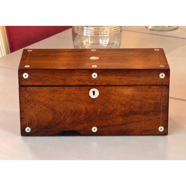 19th century rosewood box with line inlay and mother of pearl roundels, including a mother of pearl escutcheon. The...