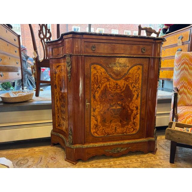 This is a French style marquetry fruitwood console table. It has a door, and shelving inside. It has a great amount of...