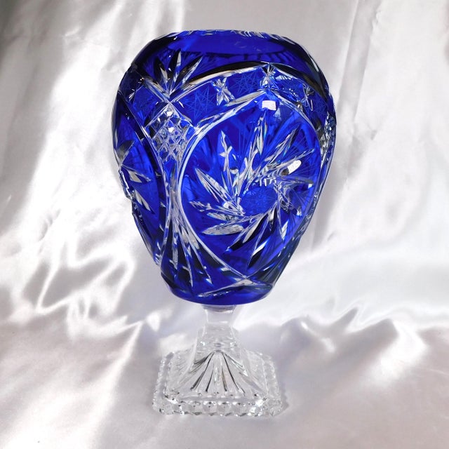 This is a very nicely done blue cut to clear vase or bowl on a clear foot. But I have one issue with it. There are four...