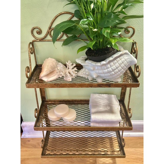This is a vintage gilt metal wall-mounted (no hardware included) shelving unit featuring three metal mesh shelves and an...