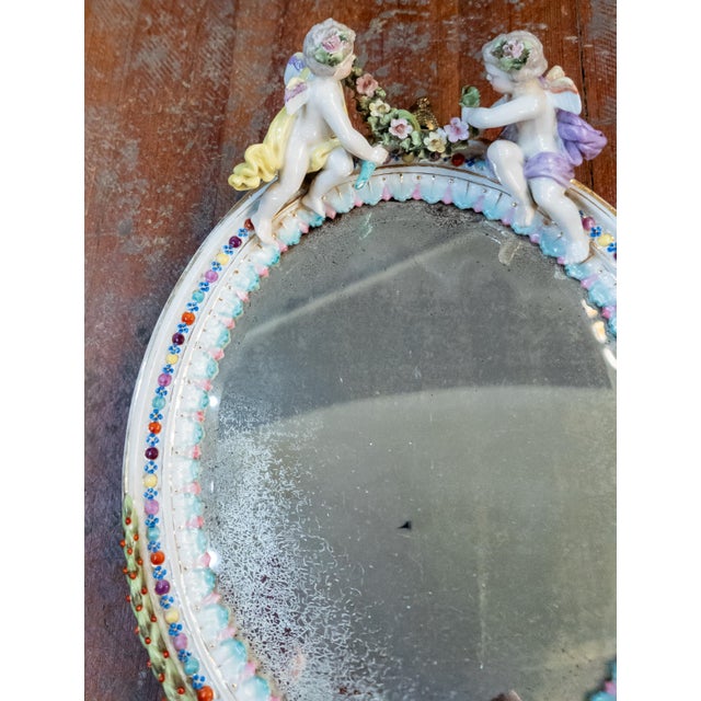We are selling this charming German Sitzendorf porcelain mirror. This mirror much in the Meissen style has two blue marks...
