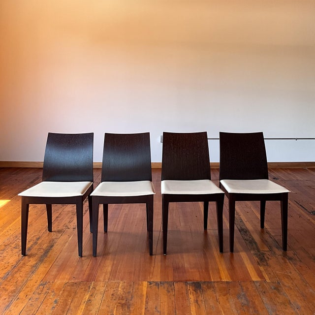 Contemporary dining chairs with white faux leather cushion. Curved dramatic back legs and contoured backrest. Dark...