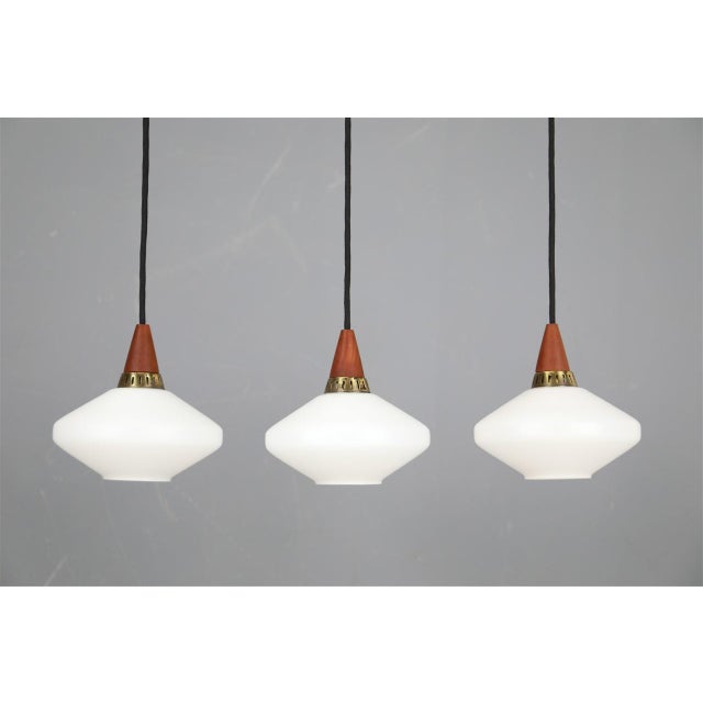 1960s, denmark. Materials: white opal glass, teak, brass. Dimensions: approx. 17 x 18 cm (height, diameter). The lamps are...
